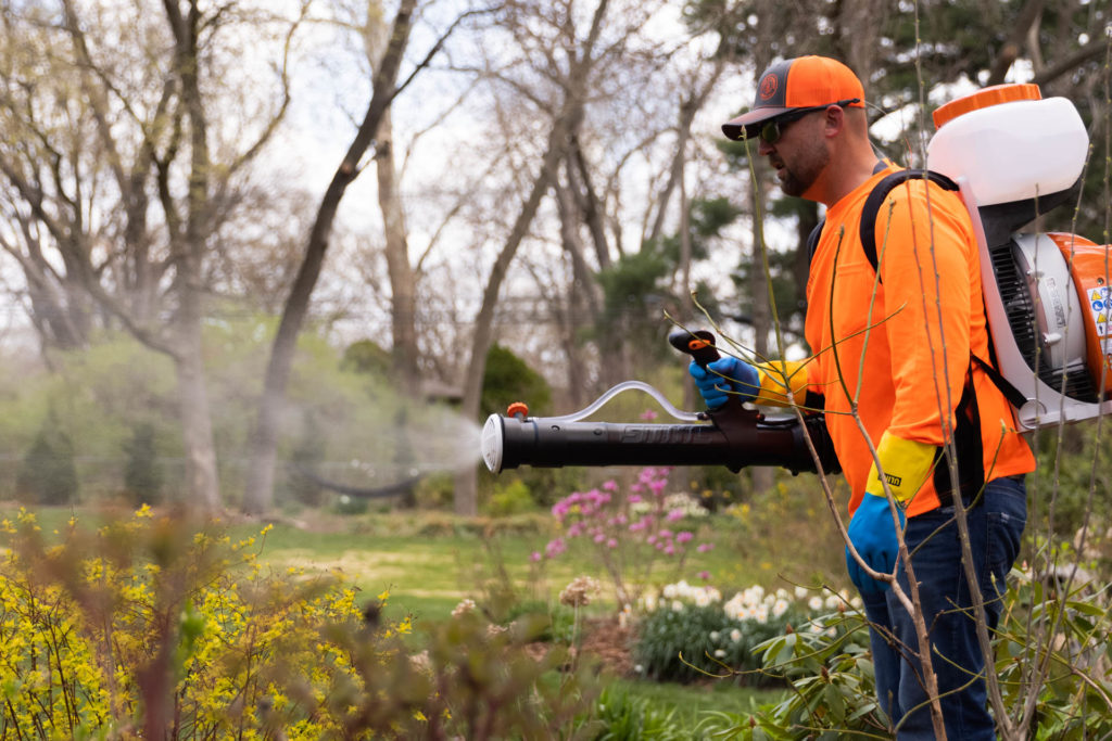 A member of our team uses a back-mounted repellent sprayer for HOA mosquito control in Leawood.