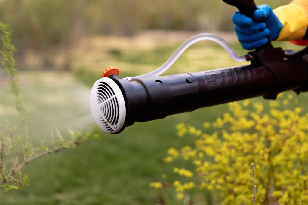A man with gloves performs HOA mosquito control in Mission Hills