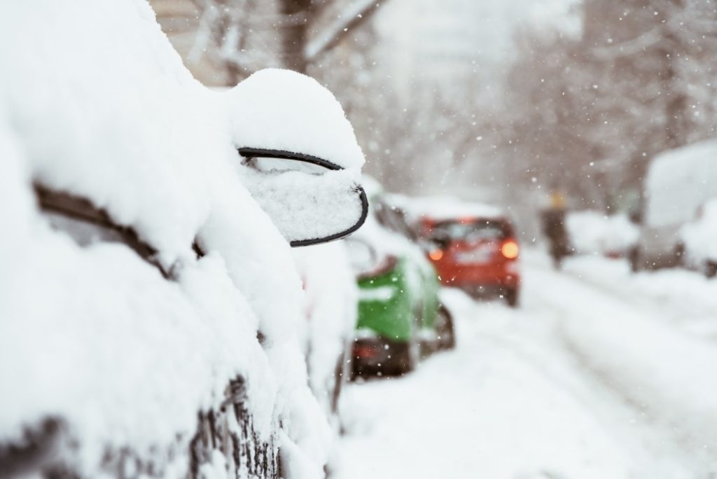 Cars parked along the street with snow covering the tops. When it's snowy, we can provide Winterizing Lawn Fertilizer in Mission Hills.